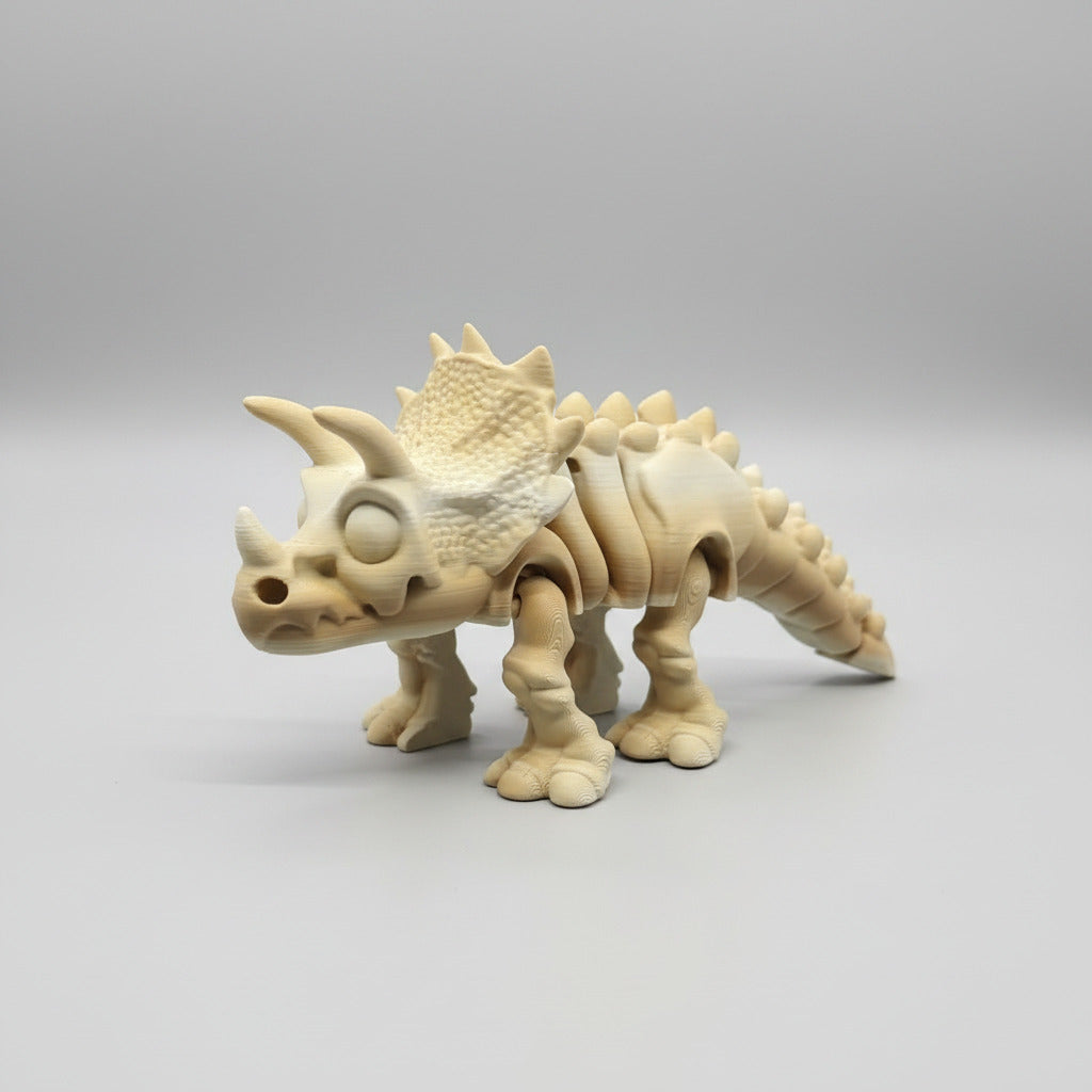 3D printed dinosaur model on a blue print bed with a 3D printer in the background