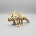 3D printed dinosaur model on a blue print bed with a 3D printer in the background