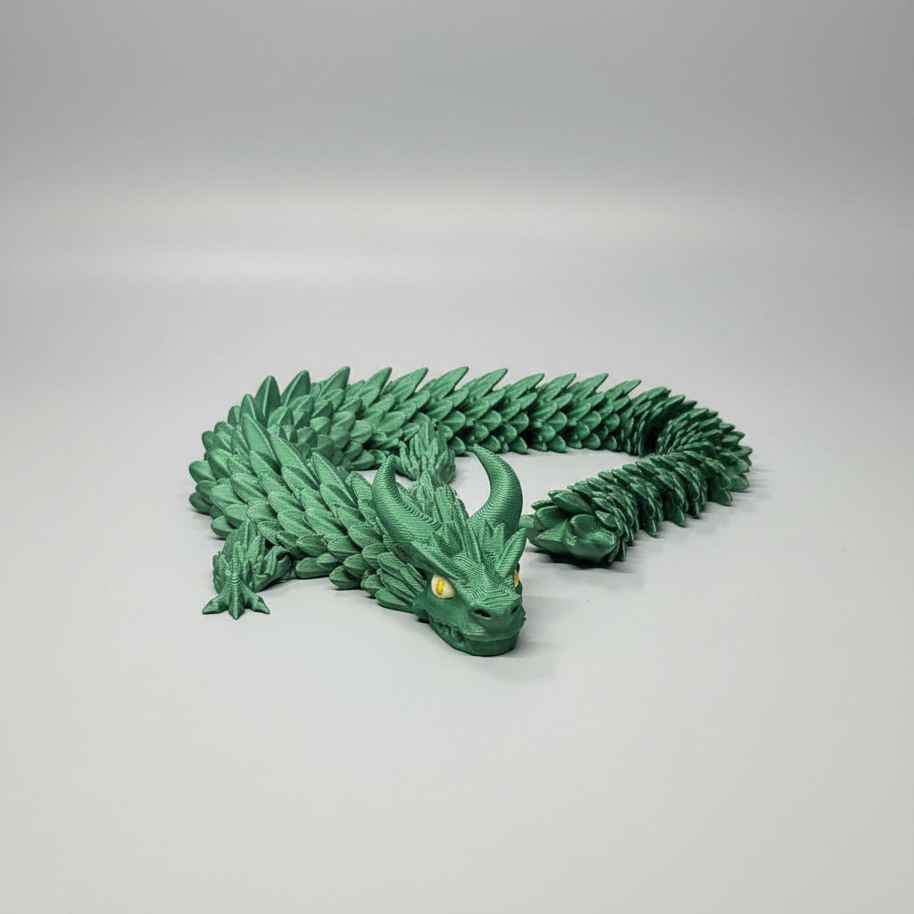 Green dragon 3D print on a blue printing surface with a blurred background